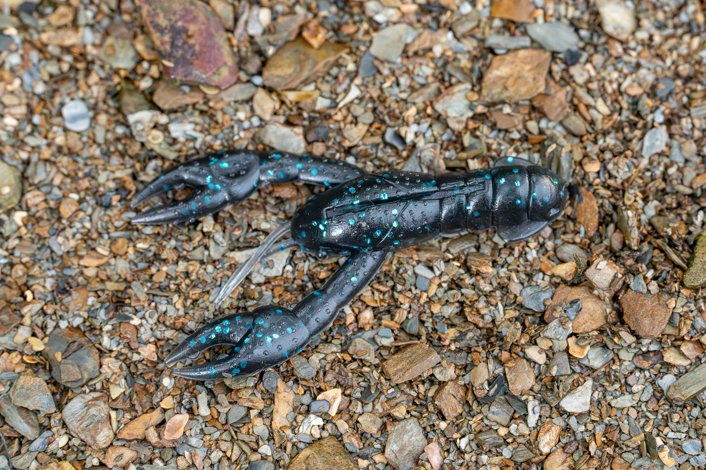 Craw lure on a bed of small stones and pebbles
