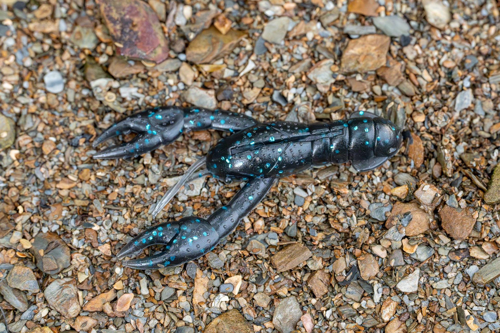 Craw lure on a bed of small stones and pebbles