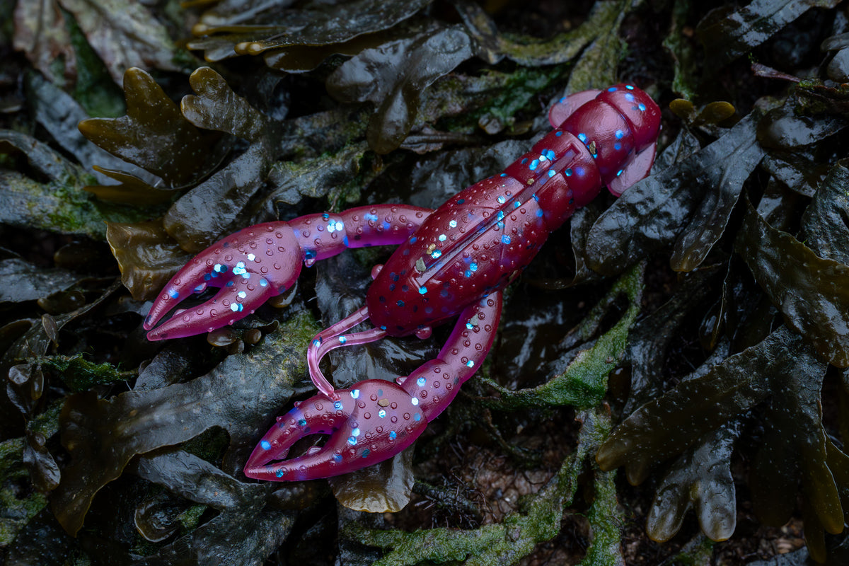 Purple plastic crab toy on a bed of seaweed
